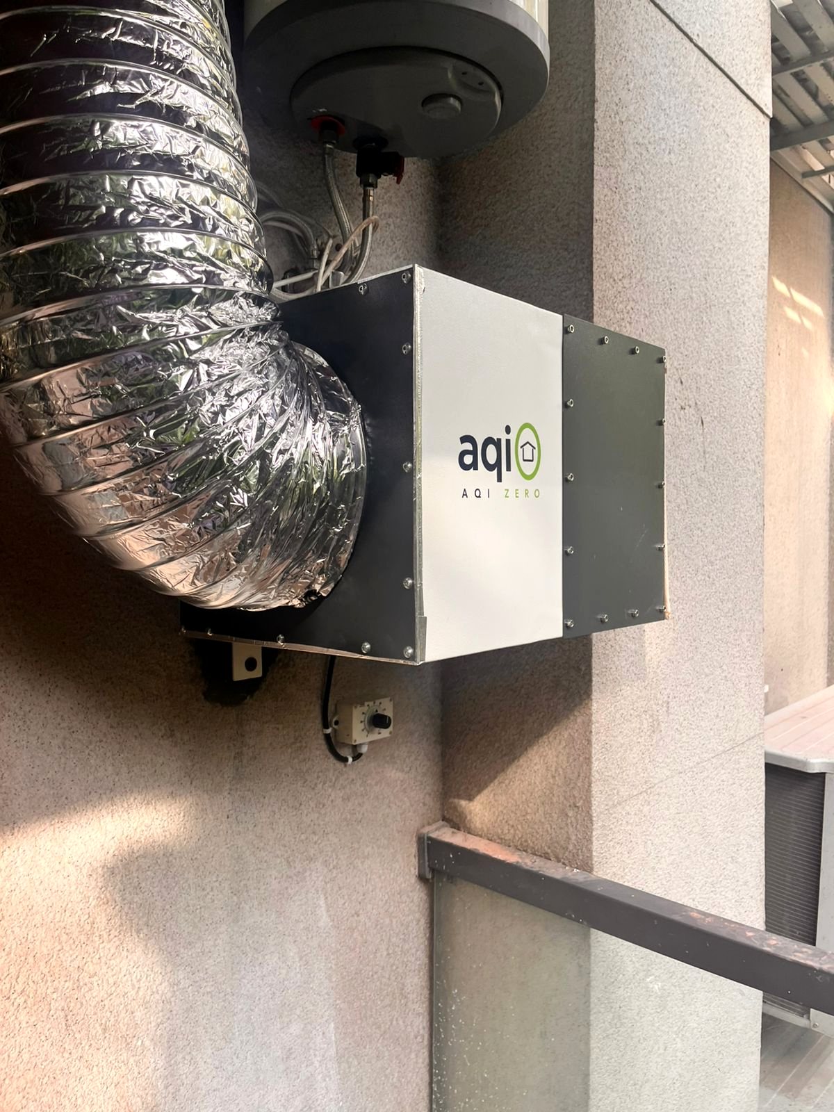 aqi0 unit mounted on a stone façade with connected ducting
